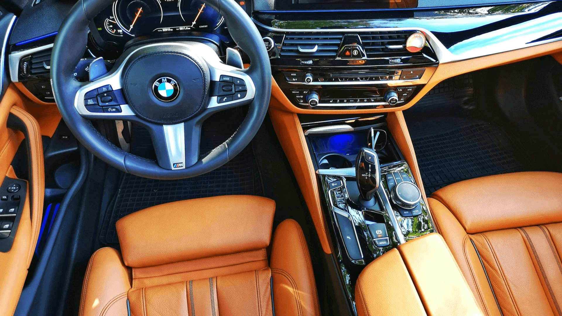 BMW interior with orange leather seats and a black steering wheel